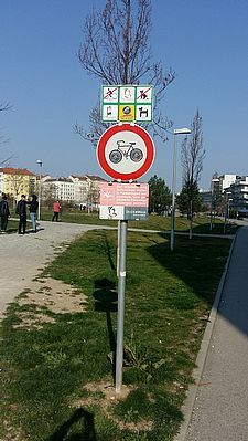 Foto einer städtischen Grünfläche mit Verbotsschildern